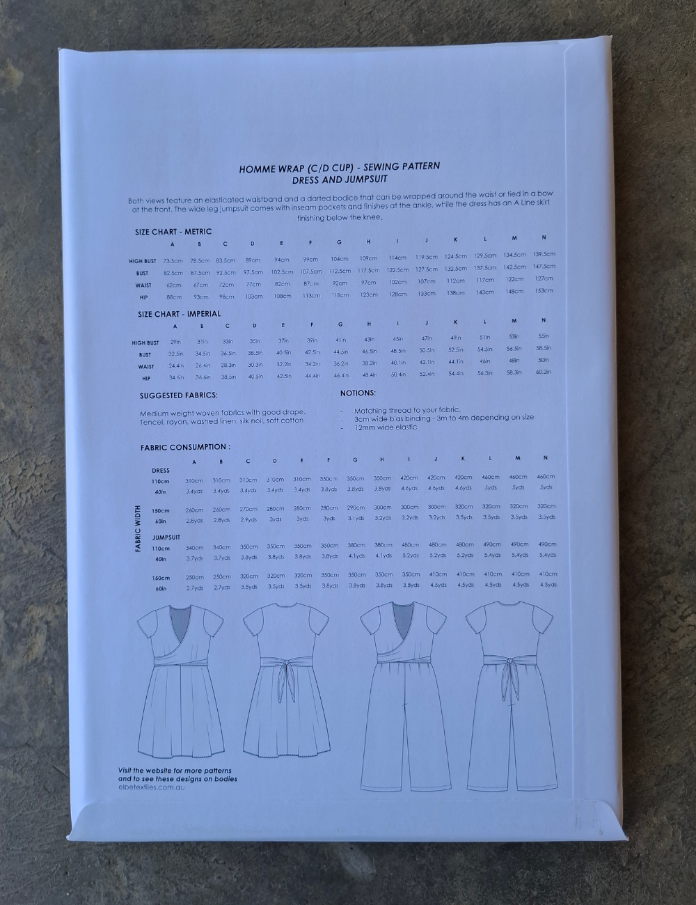Sewing pattern book with size chart and fabric consumption details on a textured surface
